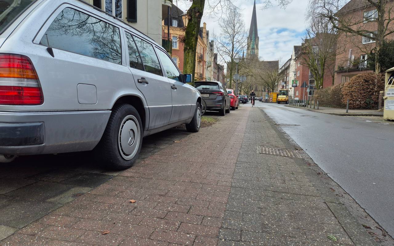 Auf dem Gehweg an einer Straße steht ein geparktes Auto. Daneben ist nur noch wenig Platz für einen Radstreifen. Vom Gehweg selbst ist nichts zu sehen.