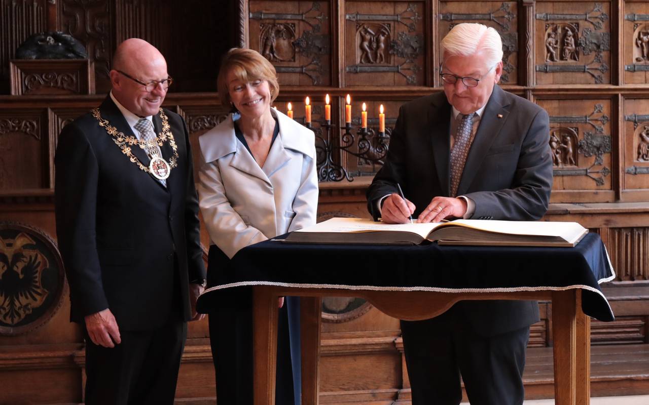 Der Bundespräsident trägt sich ins Goldene Buch der Stadt Münster ein.