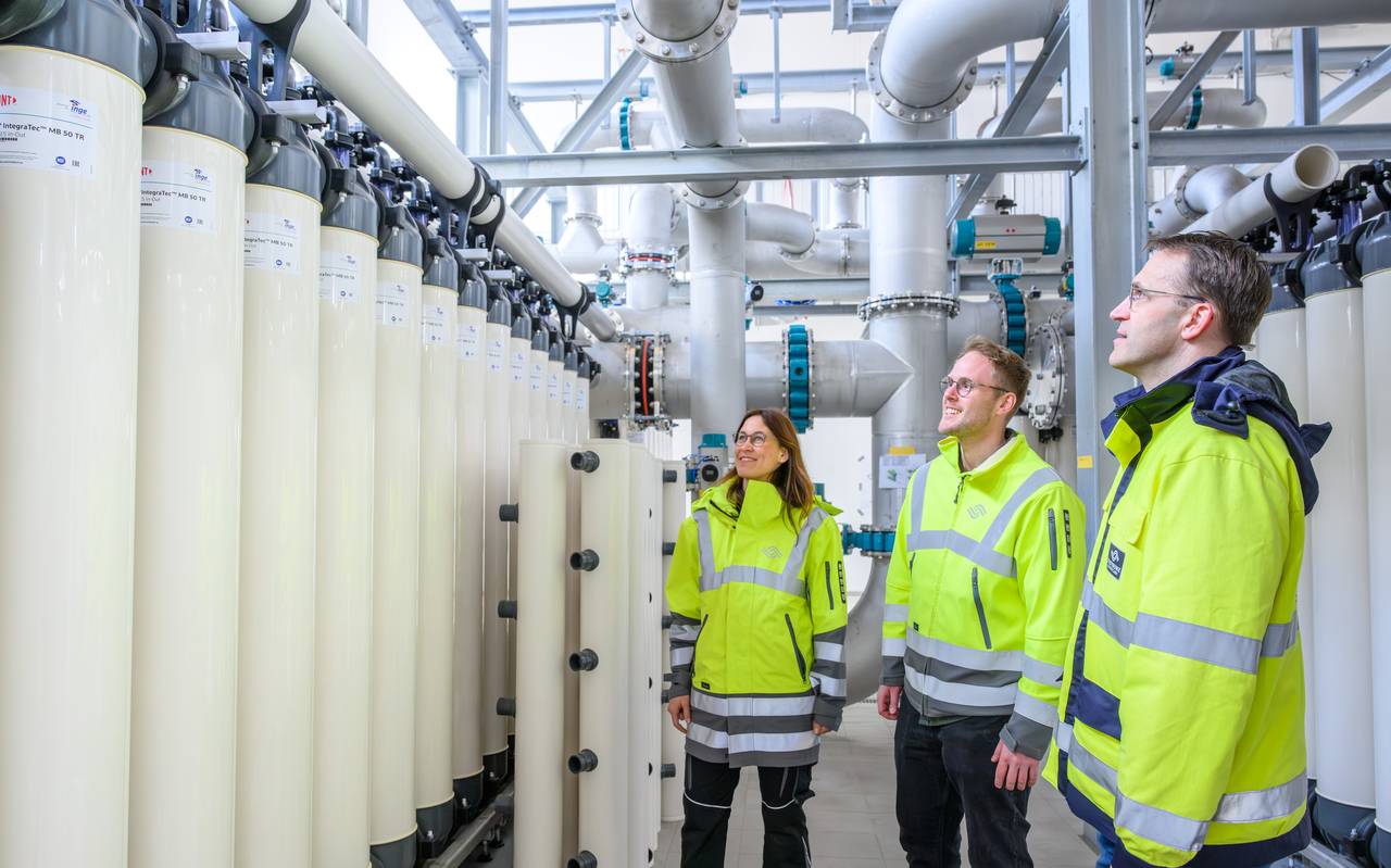 Eine Frau und zwei Männer in einem Wasserwerk.