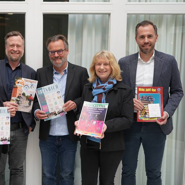 Sechs Menschen halten Schülerzeitungen in den Händen.