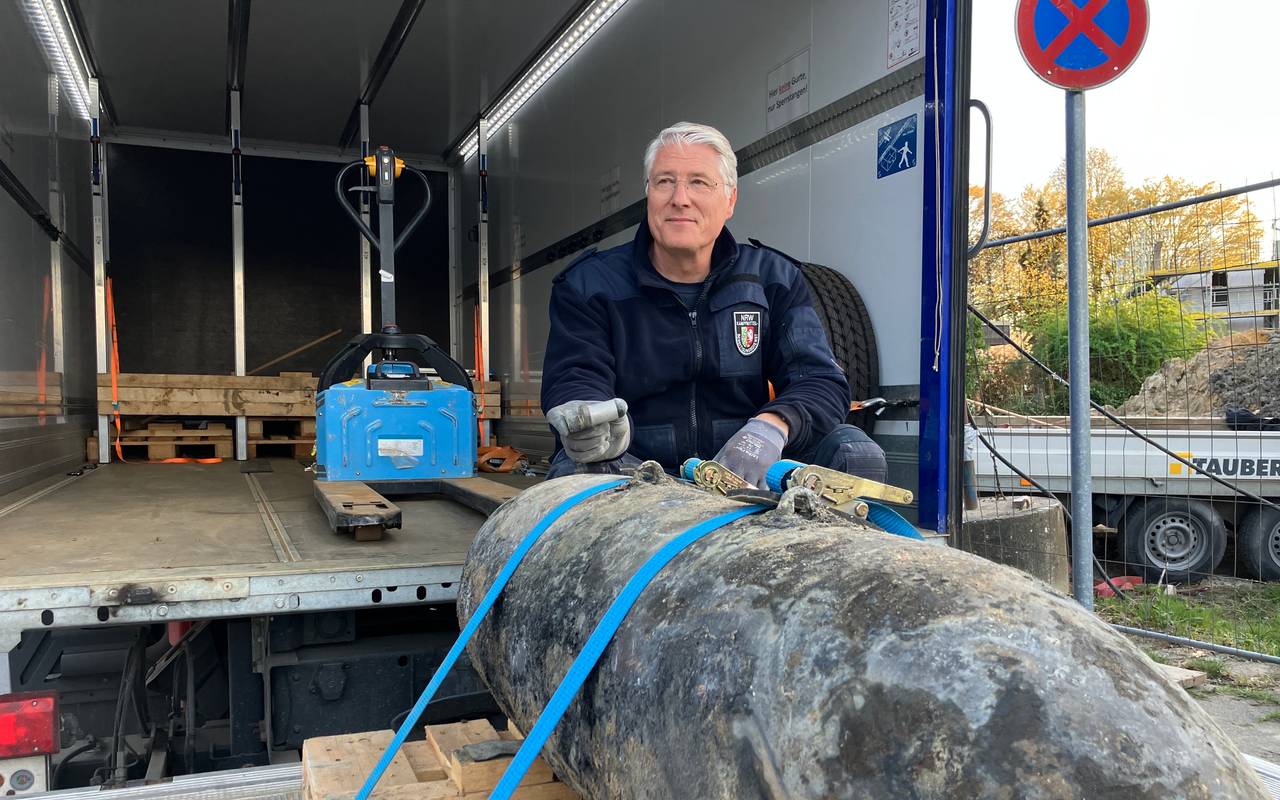 Ein Feuerwehrmann zeigt eine entschärfte Bombe