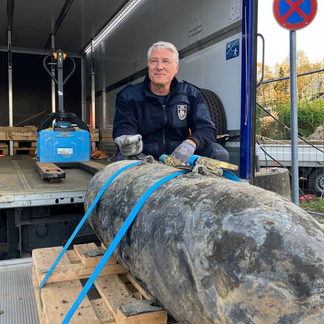 Ein Feuerwehrmann zeigt eine entschärfte Bombe