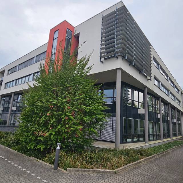 Das Gebäude des Finanzamt Münster-Innenstadt von außen. Ein modernes Gebäude mit weißer Fassade und roten Akzenten.