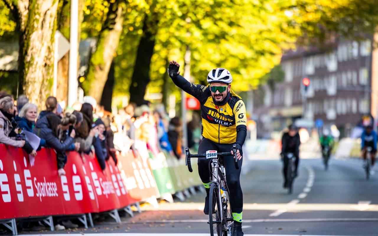 Ein Rennradfahrer jubelt auf seinem Fahrrad.