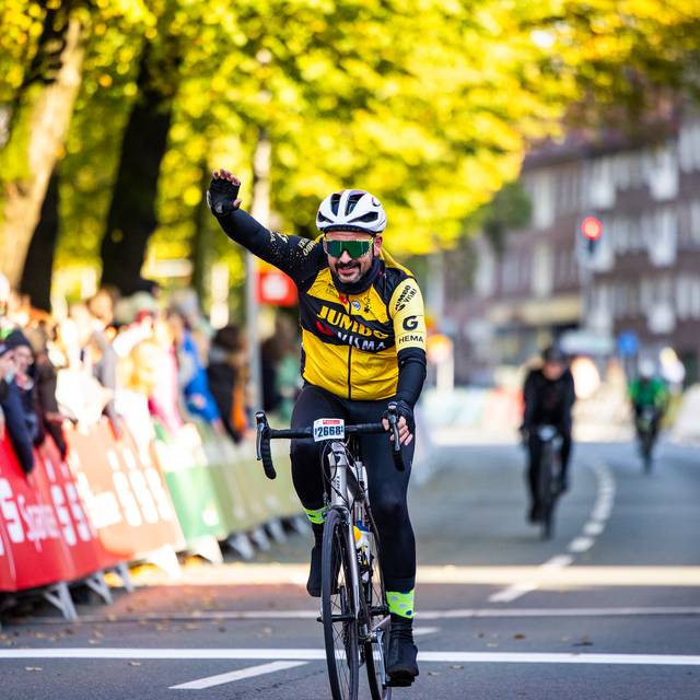 Ein Rennradfahrer jubelt auf seinem Fahrrad.