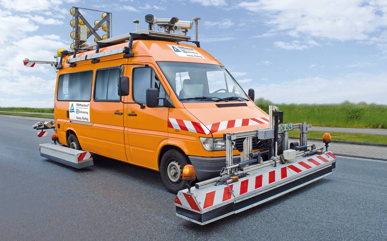 Ein großes orangenes Fahrzeug mit mehrere Gestellen am unteren Rand, die knapp über dem Boden enden.