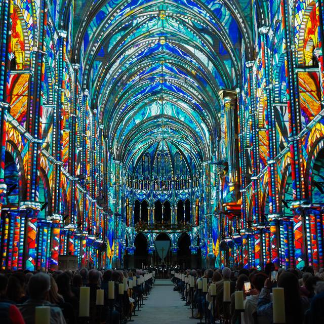 Eine dunkle Kirche ist mit farbigen Lichtern ausgeleuchtet.