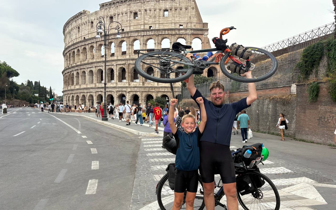 Jakob und Christian recken vor dem Kolosseum in Rom ihre Räder in die Höhe.