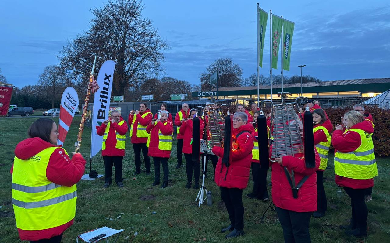 In der morgendlichen Dämmerung steht der Spielmannszug Vennheide auf einer Wiese neben der Warendorfer Straße und spielt.