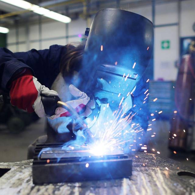 Eine Auszubildende zum Schweißer arbeitet einem Stück Metall