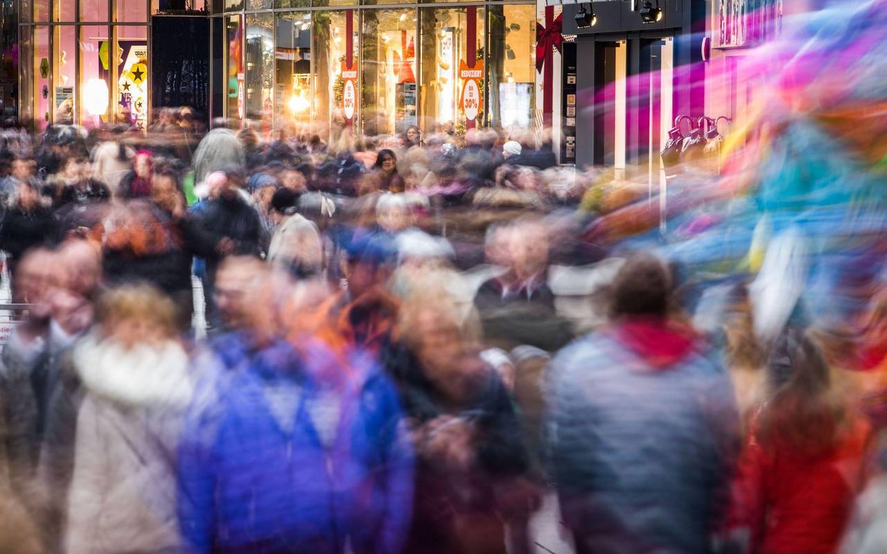 Passanten gehen vor Heiligabend über eine Einkaufsmeile