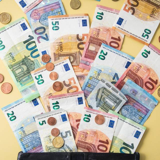 Geldscheine und Münzen fliegen aus einer Geldbörse