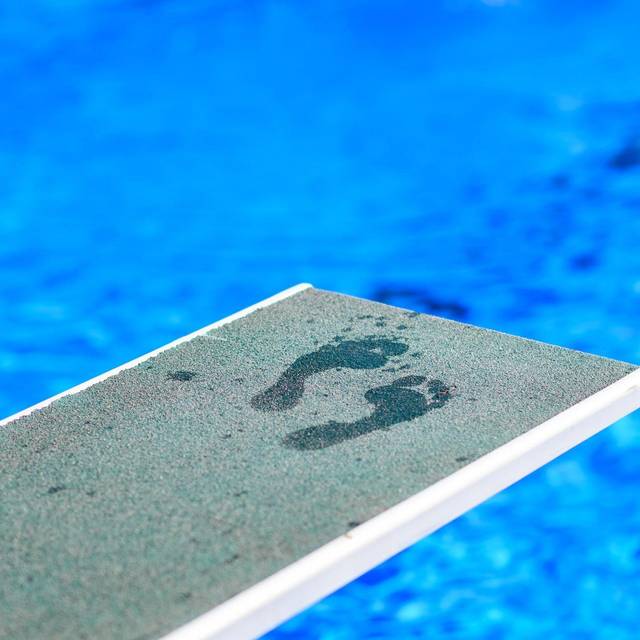 Fußabdrücke eines Badegastes auf einem Sprungbrett