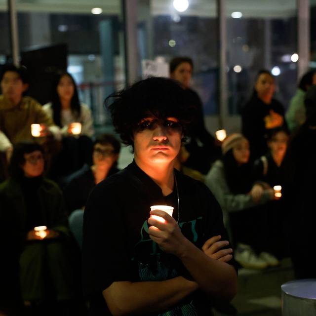 Demonstranten nehmen an einer Mahnwache bei Kerzenlicht teil.