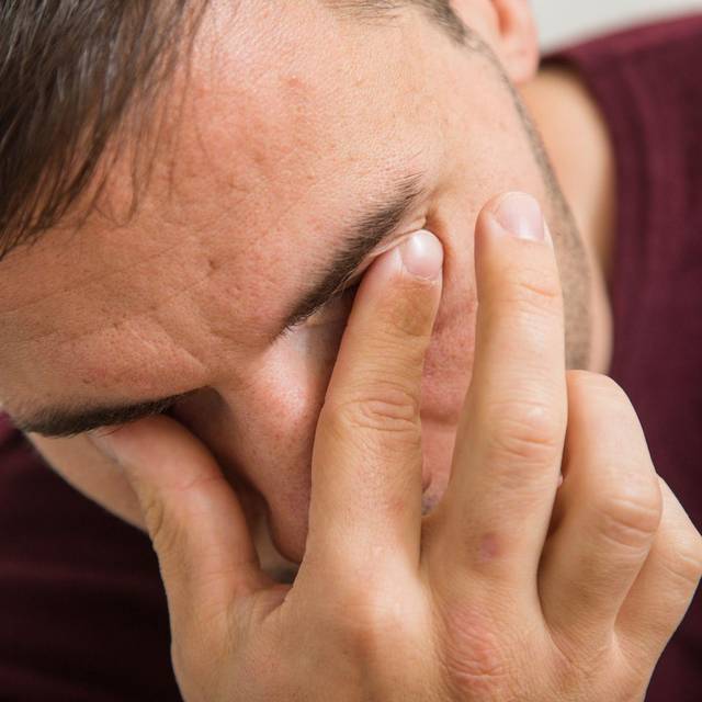 Ein Mann reibt sich die Augen