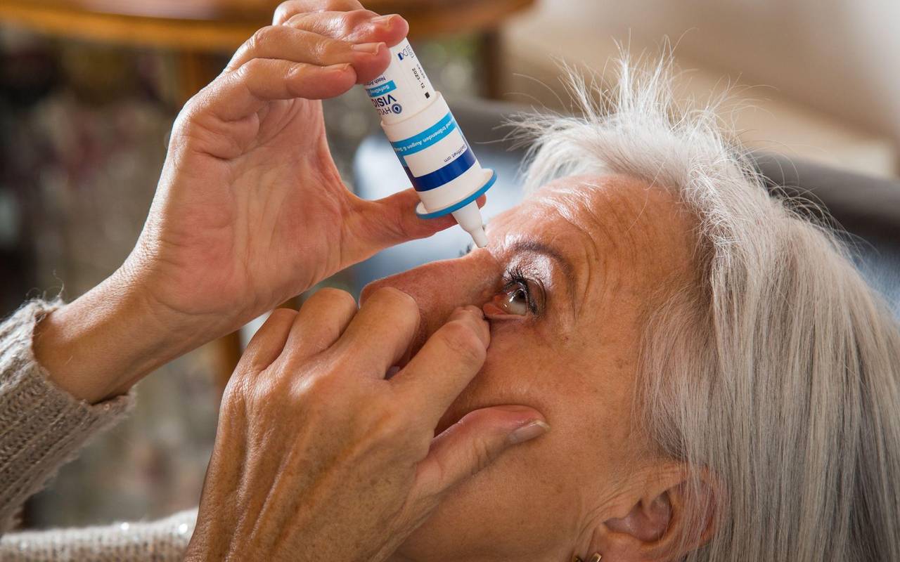 Eine Seniorin benutzt Augentropfen