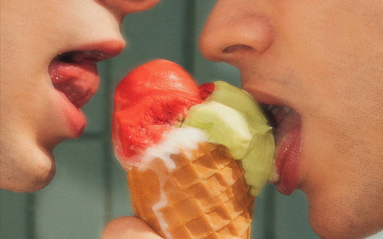 Zwei Menschen lecken an einem Eis.