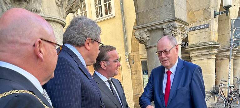 Mehrere Politiker stehen vorm Rathaus in Münster.