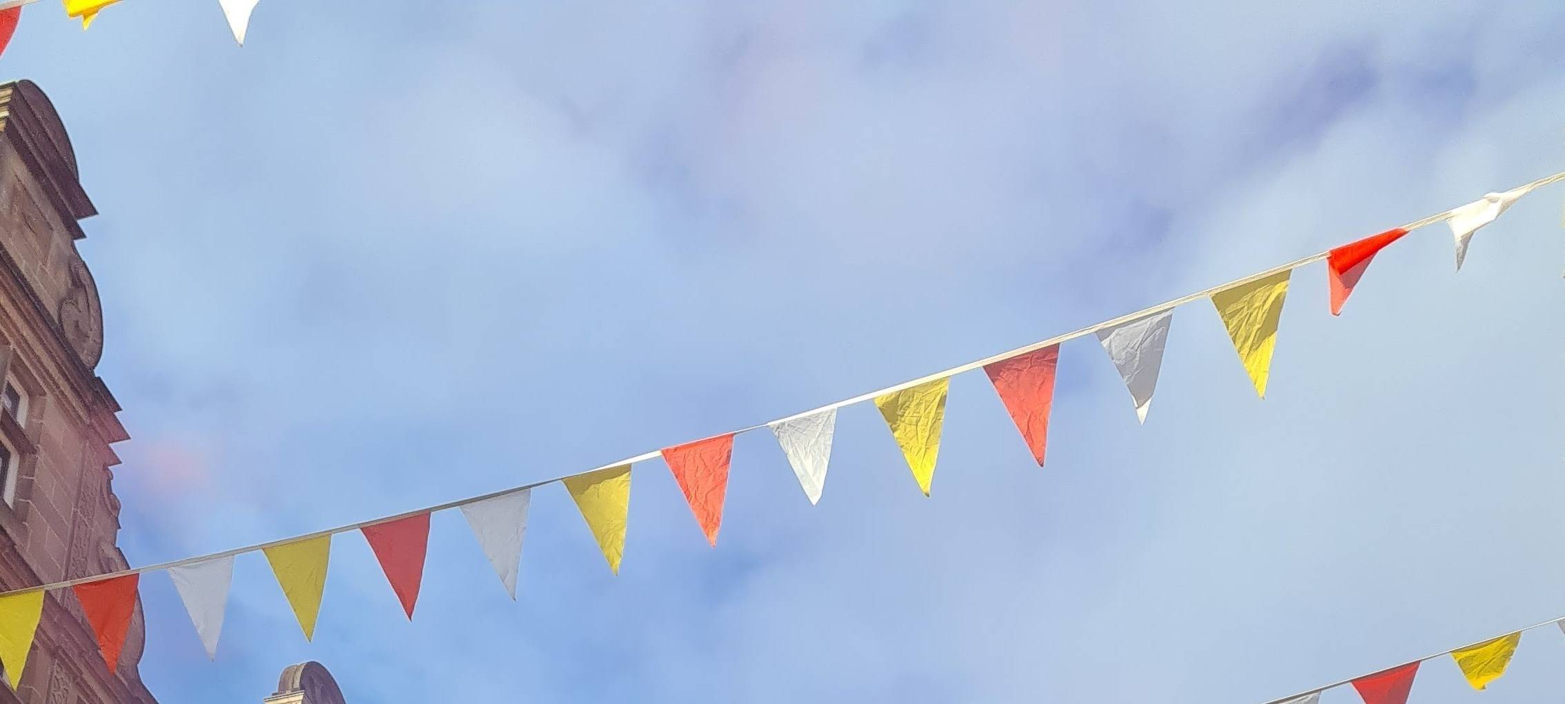 Ein Foto vom Münsteraner Prinzipalmarkt an Rosenmontag. Viele verkleidete Menschen bejubeln einen bunten Karnevalswagen.