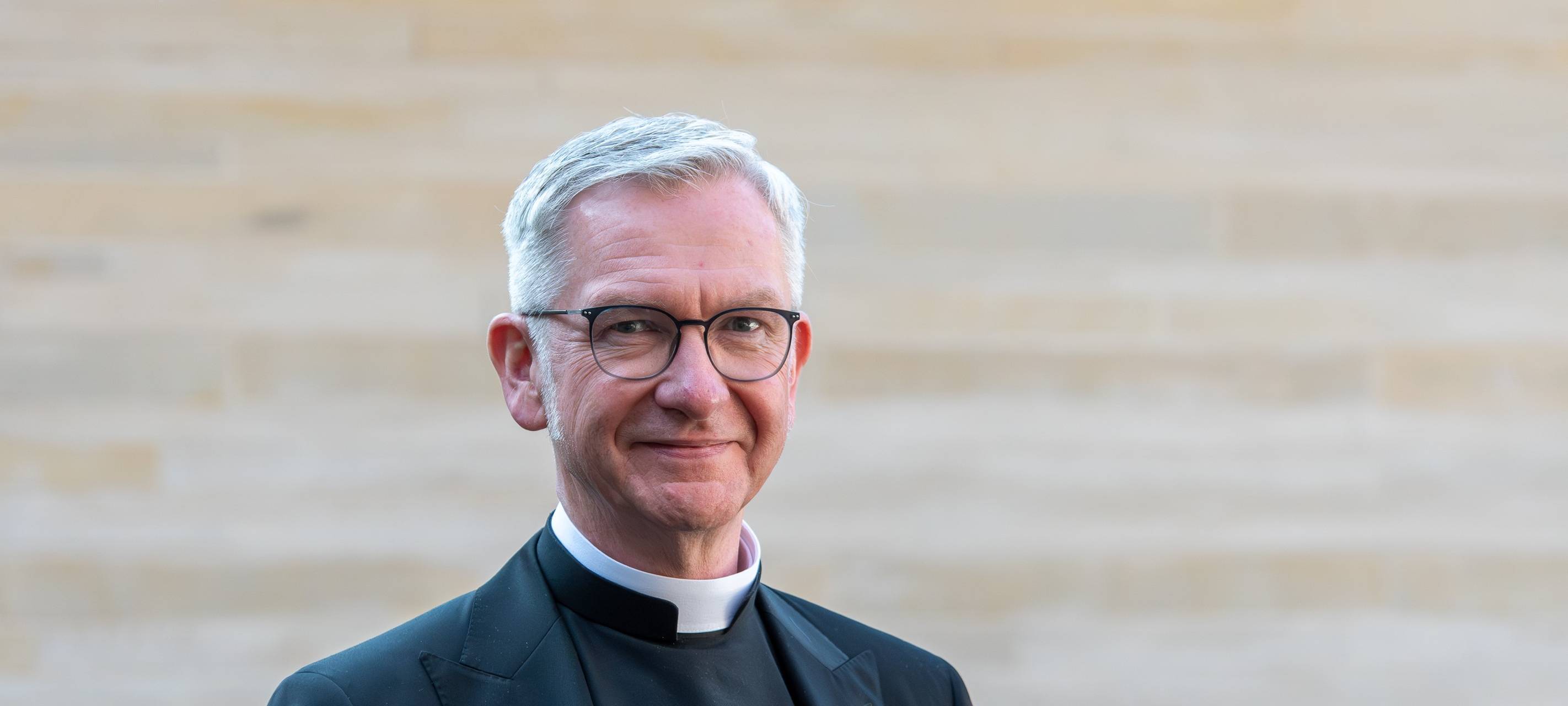 Ein Porträtfoto von Antonius Hamers. Er hat weiße kurze Haare und trägt eine Brille. Er lächelt.