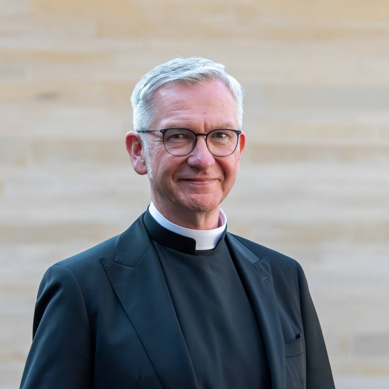 Ein Porträtfoto von Antonius Hamers. Er hat weiße kurze Haare und trägt eine Brille. Er lächelt.