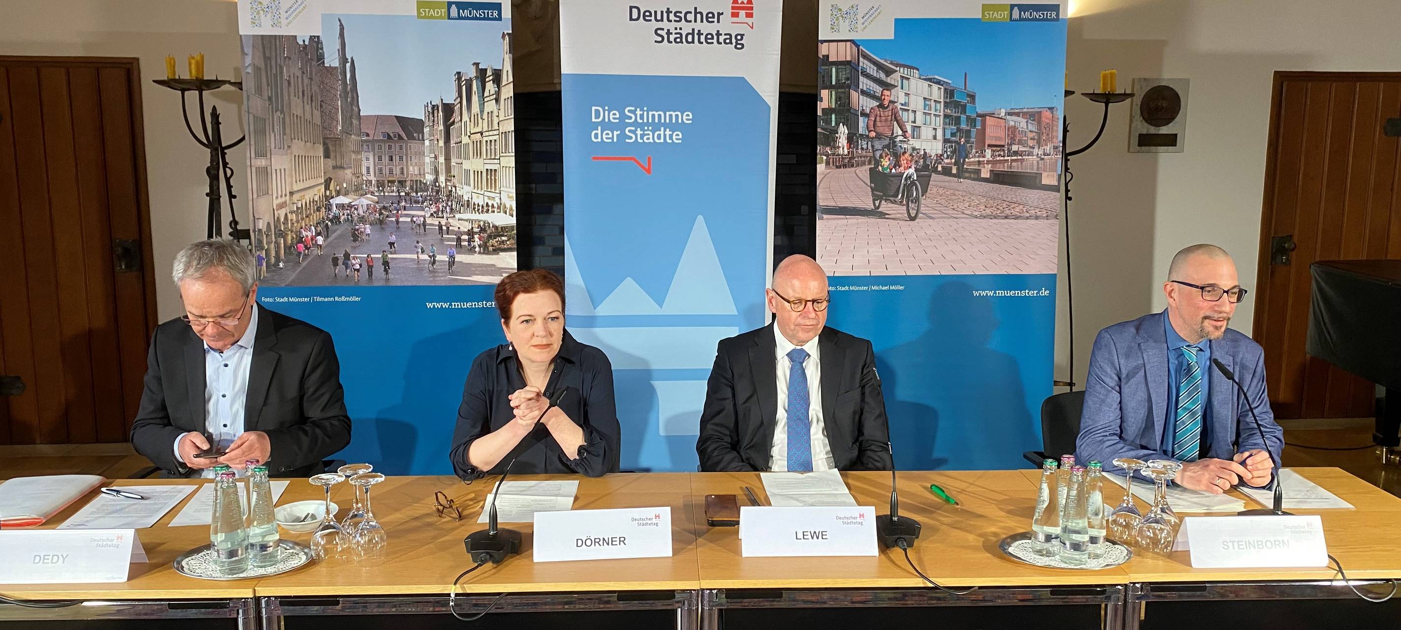 Vier Menschen sitzen an einem Tisch bei der Konferenz.