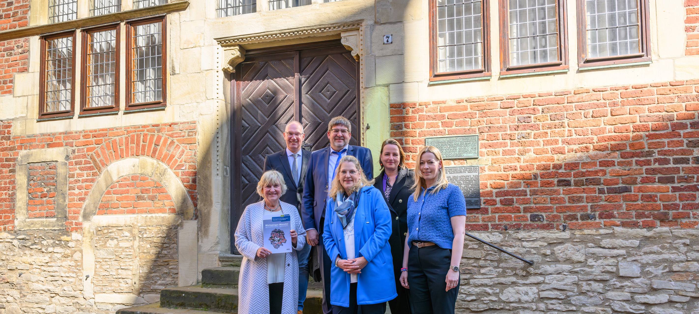 Sechs Menschen vor einem historischen Gebäude