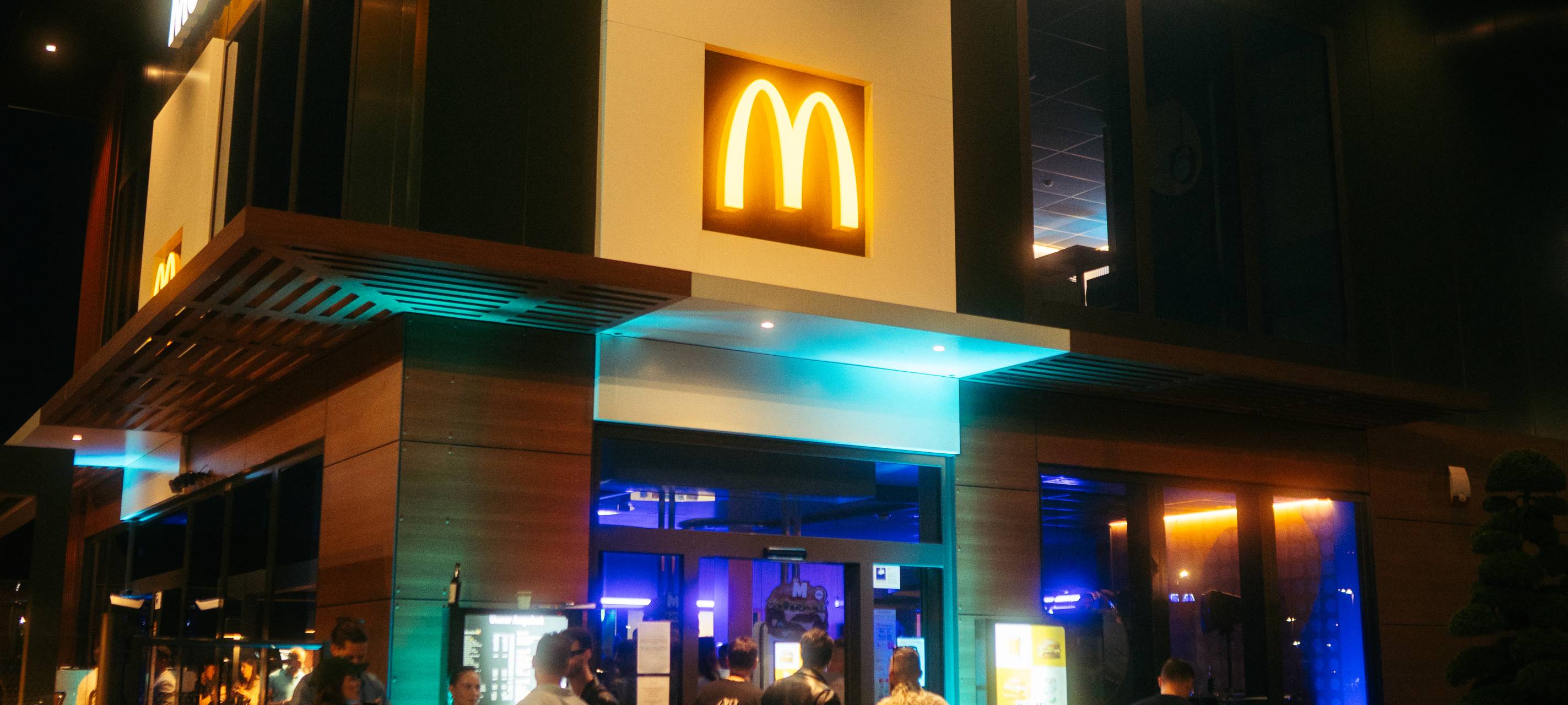 In einem kleinen Verkaufsraum feiern mehrere Menschen im dunklen Disco-Licht.