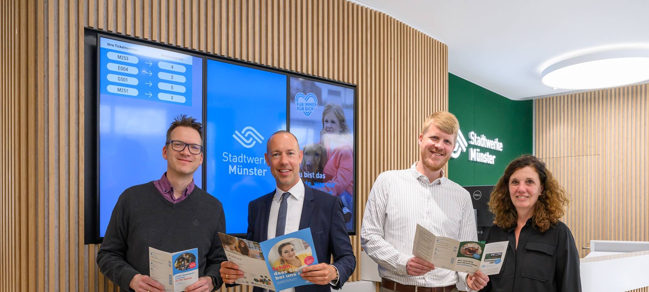 Vier erwachsene Personen in einem Gebäude der Stadtwerke Münster.