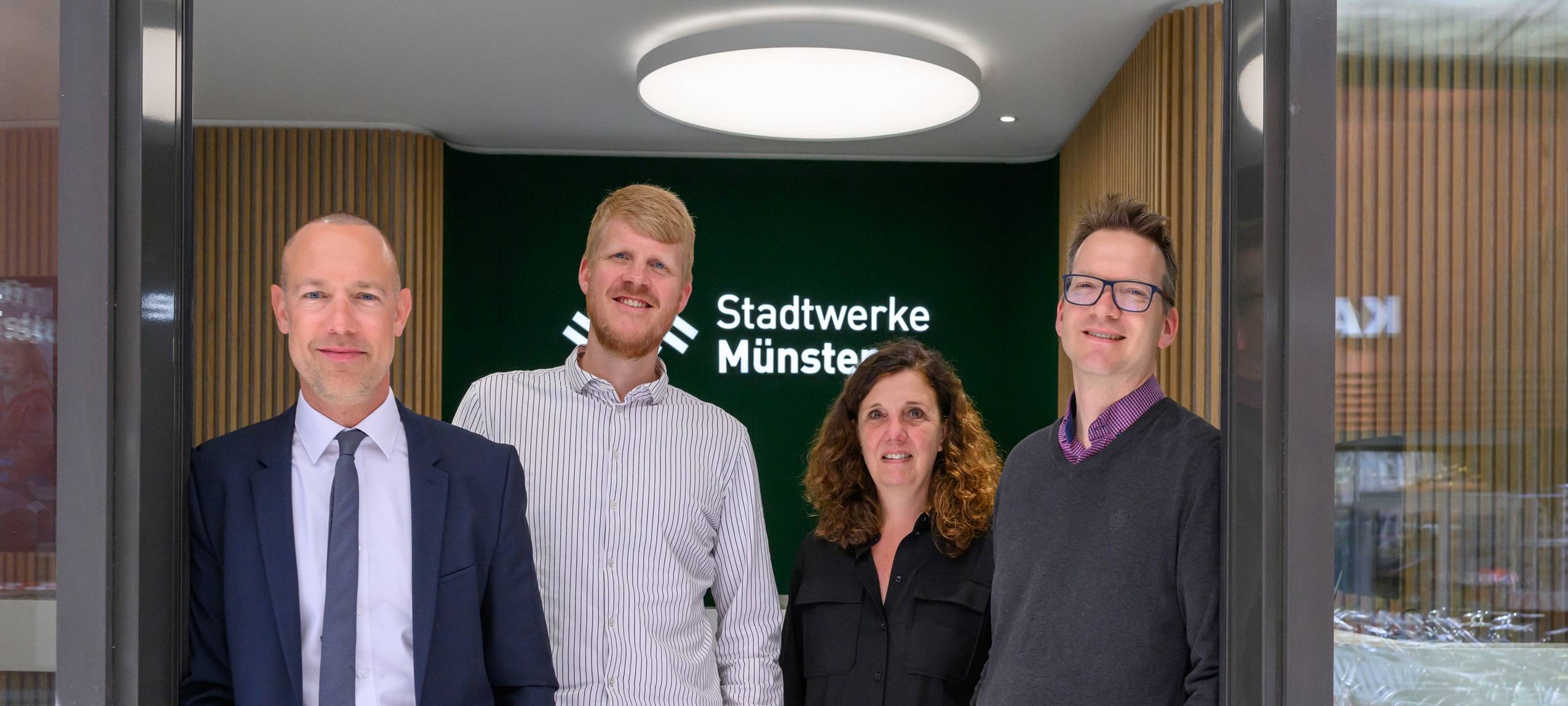 Vier erwachsene Personen in einem Gebäude der Stadtwerke Münster.