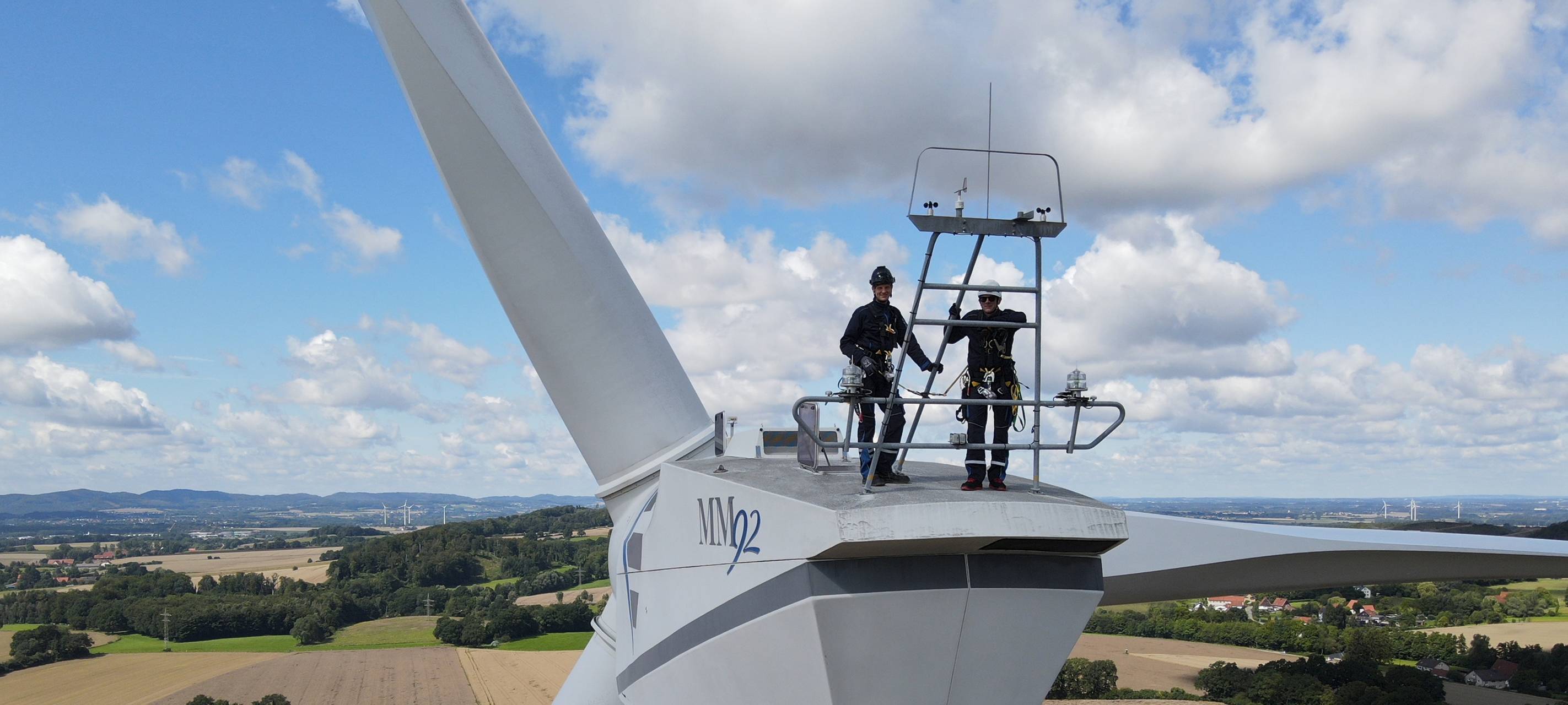 Arbeiter stehen auf einem Windrad.
