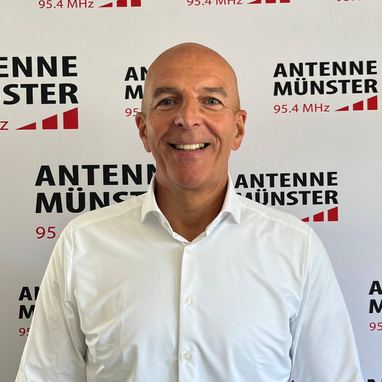 Georg Lunemann, ein Mann mit Glatze. Er trägt ein weißes Hemd.