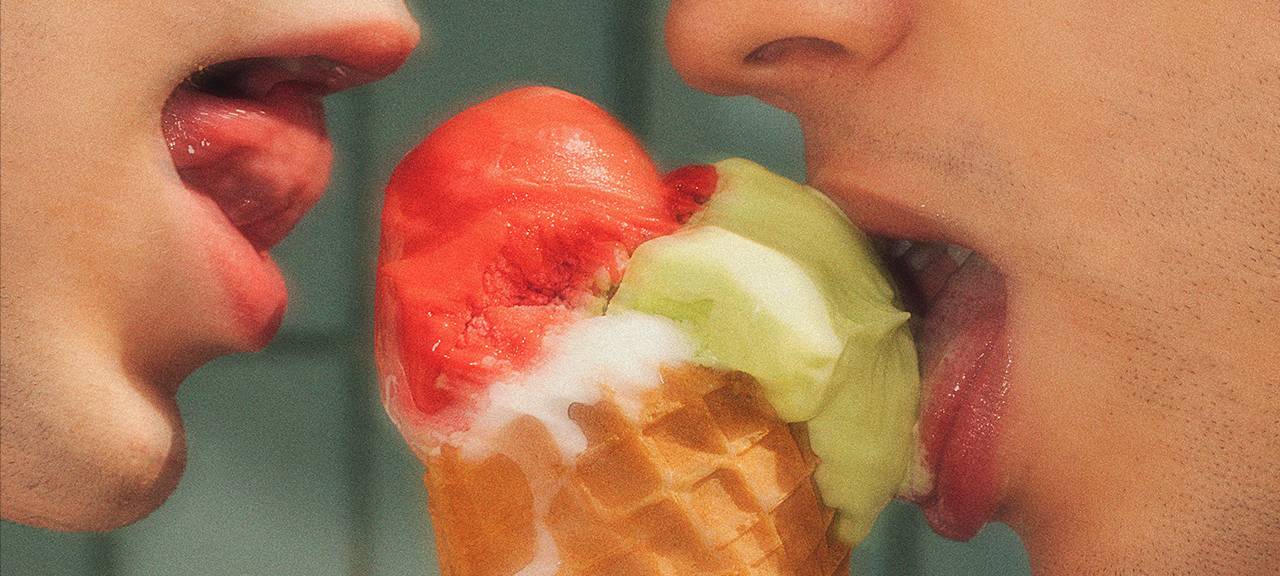 Zwei Menschen lecken an einem Eis.