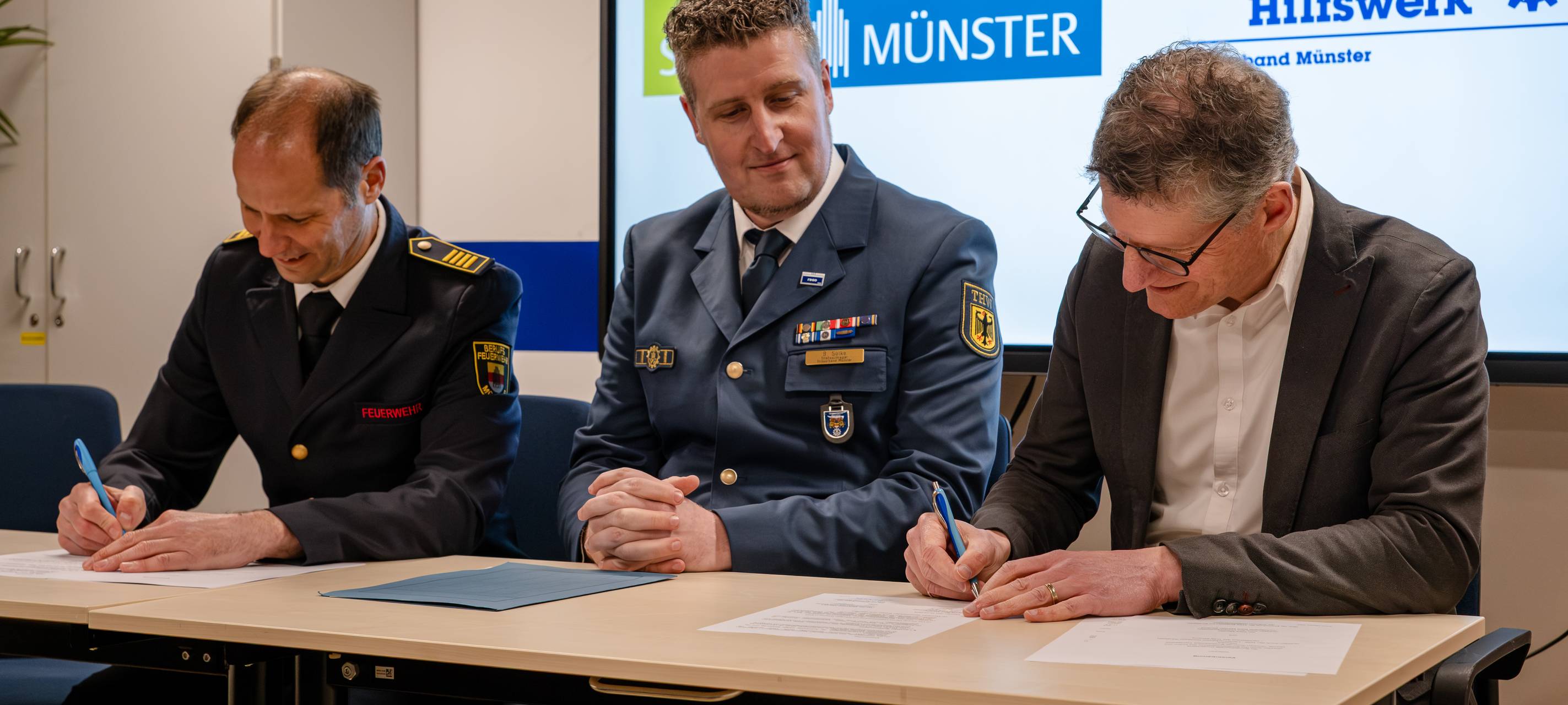 THW und Stadt Münster arbeiten künftig noch enger zusammen: Oberbürgermeister Tilman Fuchs (r.), Gottfried Wingler-Scholz (l.), Leiter des Amtes für Bevölkerungsschutz, Feuerwehr und Rettungsdienst, bei der Unterzeichnung der Vereinbarung mit Bastian Solke, Ortsbeauftragter des THW-Ortsverbandes Münster. Der Landesbeauftragte des THW, Nicolas Hefner (nicht im Bild), hatte die Vereinbarung bereits im Vorfeld unterschrieben.