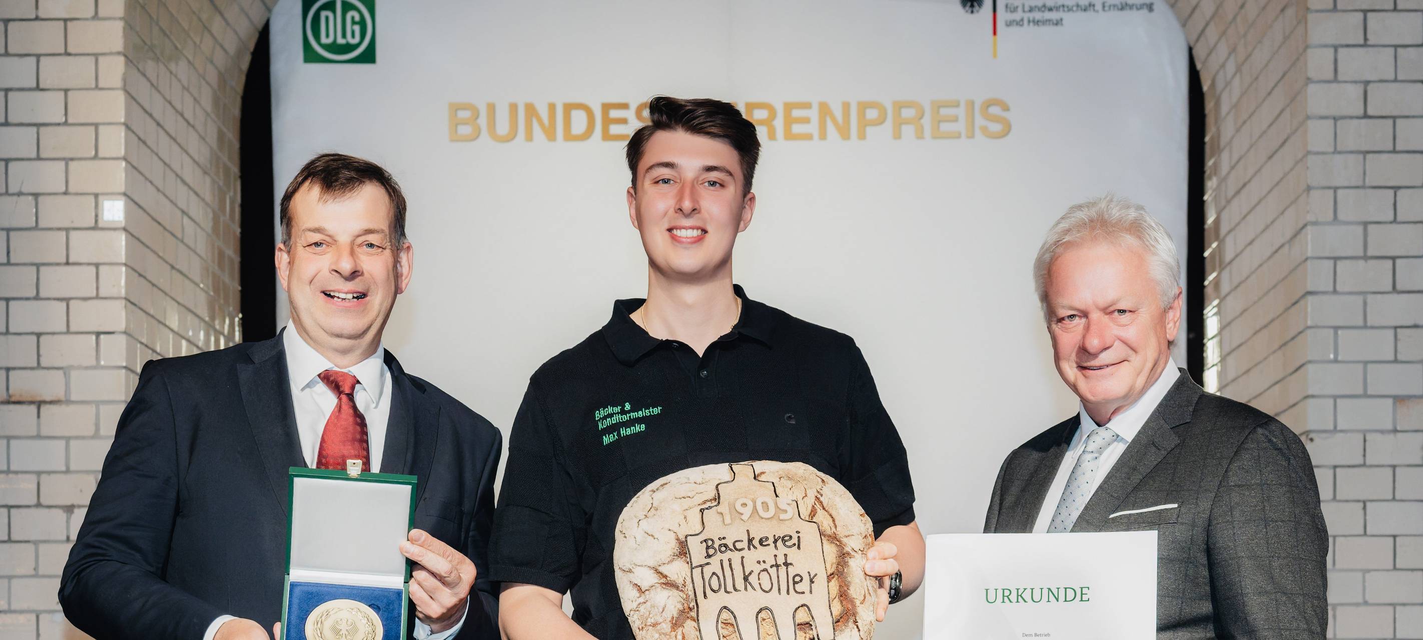 Bundesminister Alois Rainer (rechts) überreichte gemeinsam mit DLG-Präsident Hubertus Paetow (links) Urkunde und Medaille an Max Hanke.