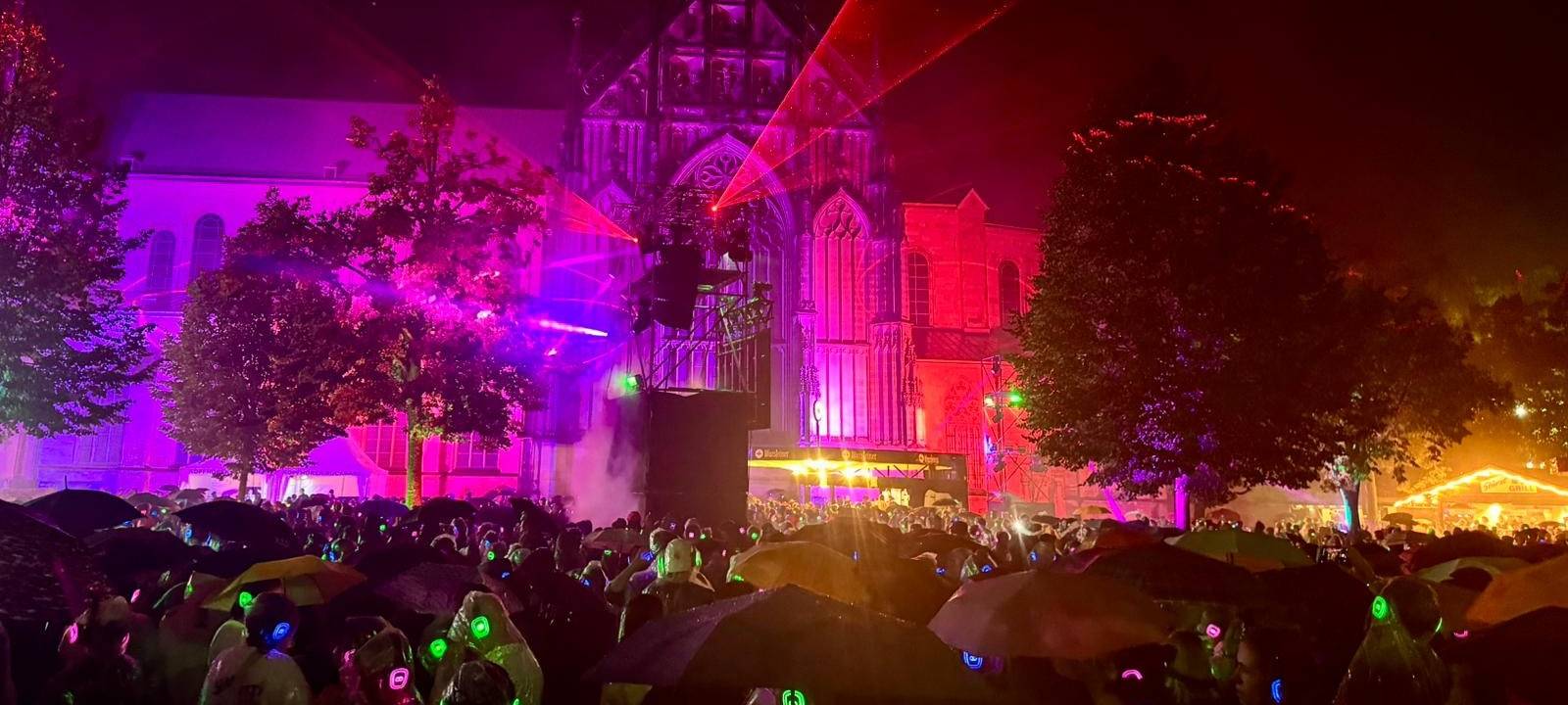 Bei der Kopfhörerparty wird Münsters Dom durch die Lasershow rot angeleuchtet.