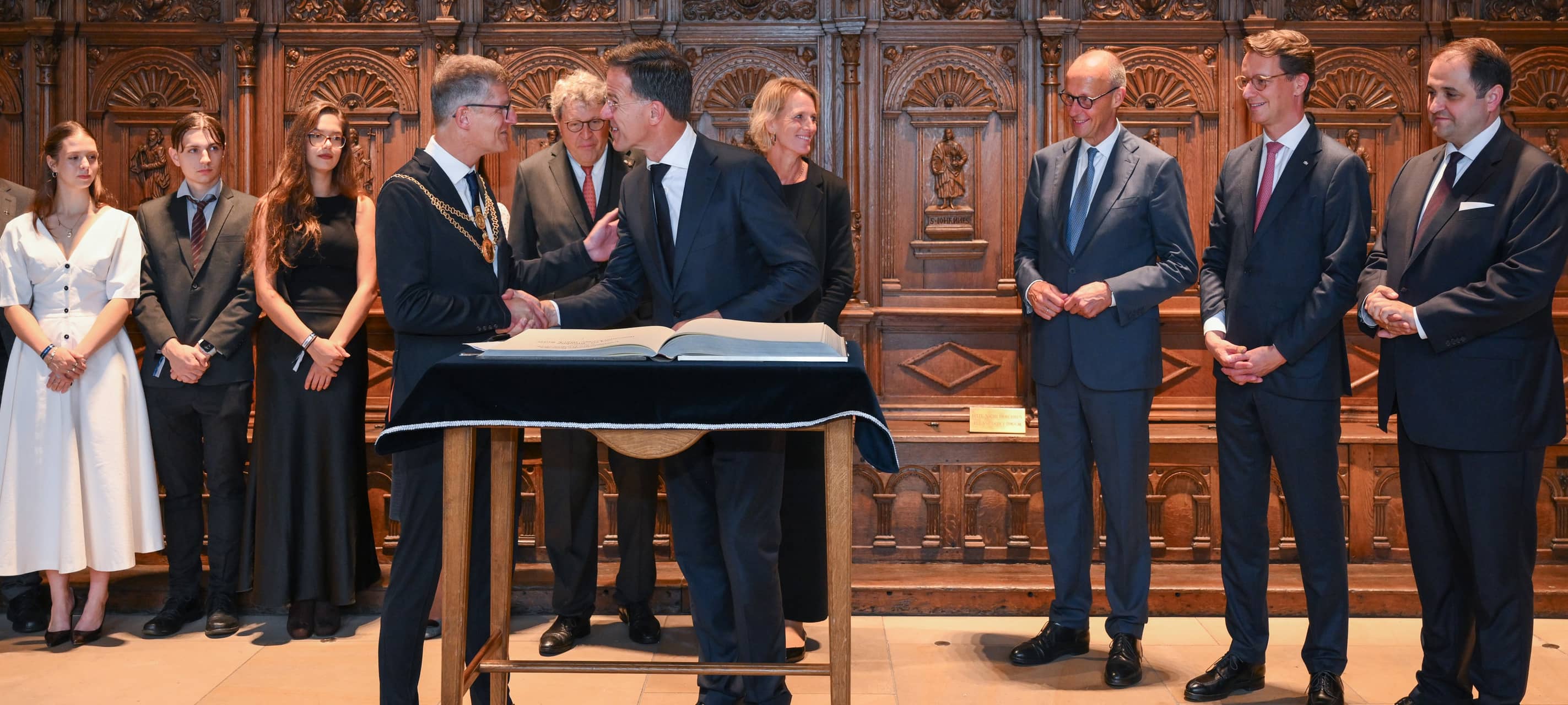 Vor der Verleihung des Westfälischen Friedenspreises empfing Münsters Oberbürgermeister Tilman Fuchs (vorne links) gemeinsam mit seiner Frau Claudia NATO-Generalsekräter Mark Rutte (vorne rechts) und weitere Gäste im Friedenssaal. Rutte trug sich in das Goldene Buch der Stadt Münster ein, ebenso wie (v. l. n. r.) die drei Jugendlichen von socioMovens, Ana Novotni, Gábor Reisz, Daria Maria Lung, der WWL-Vorsitzende Reinhard Zinkann, Bundeskanzler Friedrich Merz, NRW-Ministerpräsident Hendrik Wüst und Nathanael Liminski, Chef der NRW-Staatskanzlei.