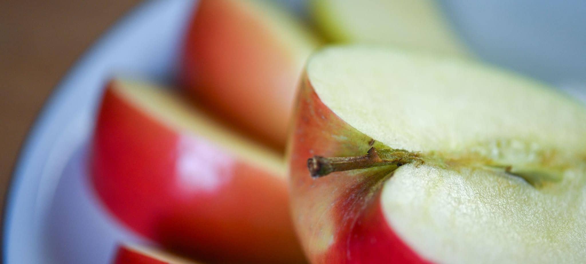 Aufgeschnittener Apfel liegt auf einem Obstteller
