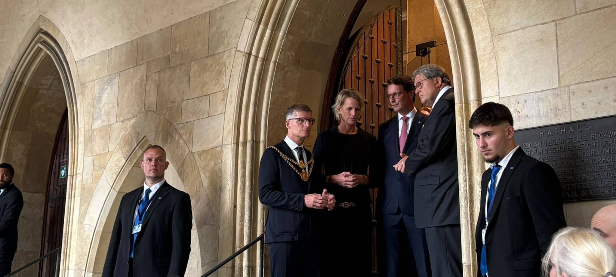In der Tür des Historischen Ratauses wird auf die Gäste gewartet.